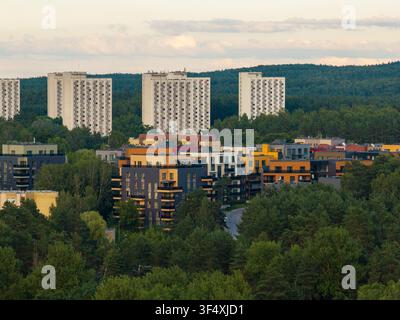 Vista aerea di moderni edifici residenziali circondati da foreste rigogliose e alti blocchi torre dell'era sovietica a Vilnius, contea di Vilnius, Li Foto Stock