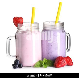 Milkshakes di diversi gusti in barattoli Mason e ingredienti isolati su sfondo bianco Foto Stock