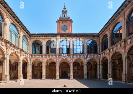Bologna, Italia - Maggio 2026: Cortile e torre dell'orologio dello storico Palazzo Archiginnasio circondati da arcate Foto Stock