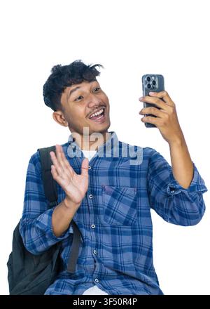 Un giovane uomo sudasiatico allegro con i capelli ricci e i baffi si gode una conversazione telefonica Foto Stock