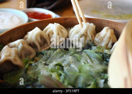 Mangiare gnocchi con verdure in un vaporetto di bambù Foto Stock