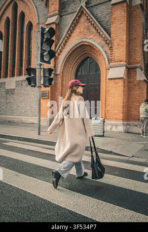 Donna che attraversa la strada vicino alla Union Church con i bagagli, Shanghai Foto Stock