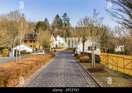 Una strada acciottolata si snoda attraverso il villaggio storico di Kronenburg, Germania Foto Stock