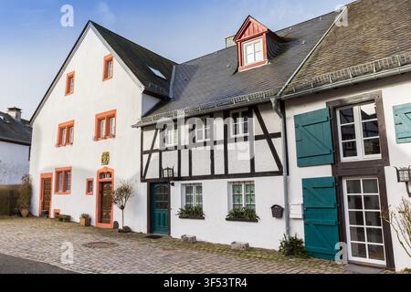 Case a graticcio costeggiano una storica strada acciottolata a Kronenburg, Germania Foto Stock
