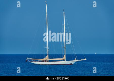 Schiuner classico a due alberi, Elena, barca a vela ancorata su un mare blu calmo sotto un cielo sereno Foto Stock