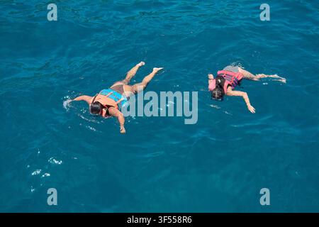 Gran Canaria, Spagna – 31 luglio 2026: Veduta aerea di nuotatori che esplorano acque oceaniche limpide con giubbotti di salvataggio durante un’avventura marina. Foto Stock