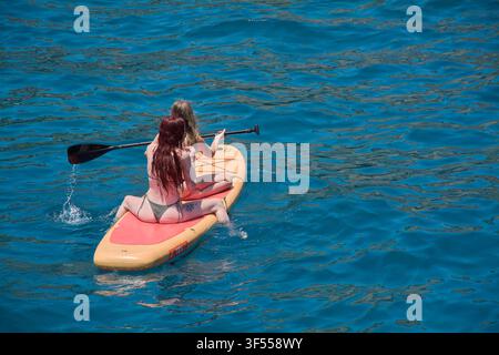 Gran Canaria, Spagna – 31 luglio 2026: Veduta aerea di amici che si divertono a fare stand up paddle in acque marine limpide. Foto Stock