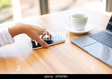 Immagine laterale di una donna che tiene in mano uno smartphone Foto Stock