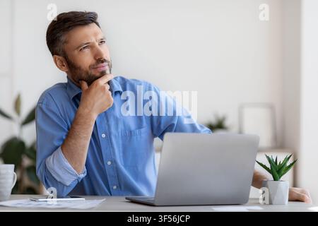 Ritratto di uomo d'affari Pensive Millennial pensando al progetto Busines a. Luogo di lavoro Foto Stock