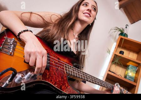 Giovane bassista che pratica la musica con una prospettiva creativa Foto Stock
