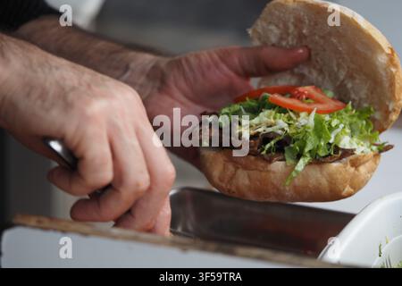 Preparare un sandwich con carne e verdure fresche Foto Stock