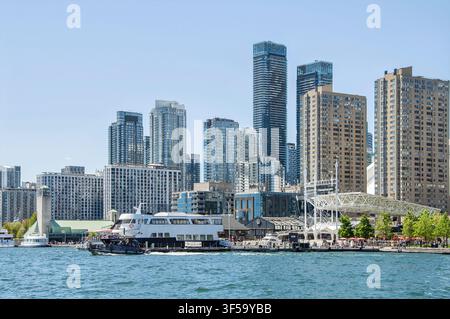 TORONTO, ONTARIO, CANADA - 30 MAGGIO 2026: Skyline del centro di Toronto con grattacieli moderni e traghetto turistico sul Lago Ontario vicino a Canada Place. Foto Stock