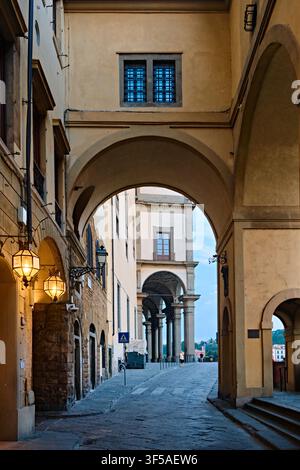 Firenze, Italia - Maggio 2026: Passaggio ad arco della Galleria degli Uffizi che conduce all'Arno con lanterne storiche Foto Stock