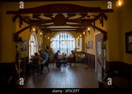 Kimry, Oblast di Tver, Russia, 25 luglio 2026 – Persone sedute in un interno vintage Art Nouveau di un caffè con finestra rotonda. Il Café 1909 si trova all'interno del famoso Foto Stock