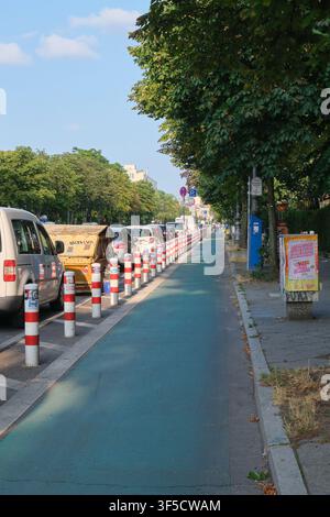 Berlino, Germania, 18 luglio 2026: Un percorso ciclabile dipinto di verde, protetto da new jersey nella Hasenheide Foto Stock