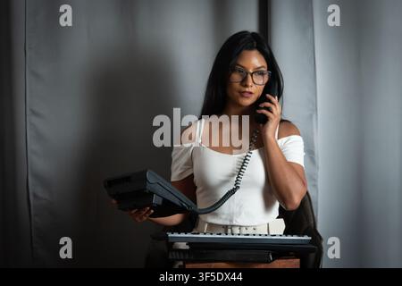 Giovane donna d'affari con occhiali che parla al telefono Foto Stock