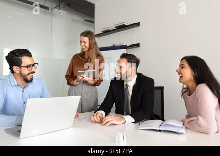 Gruppo di membri di una squadra professionale multietnica che ride durante la discussione Foto Stock