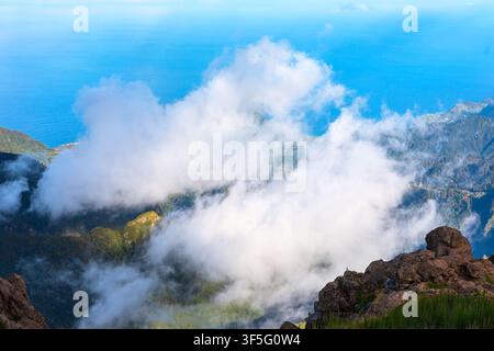 Il Pico do Arieiro offre una vista mozzafiato su Madeira sopra le cime montuose affilate che emergono da una spessa coltre di nuvole bianche. Oceano di un blu profondo Foto Stock