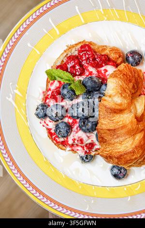 Croissant gourmet con formaggio burrata, bacche fresche e miele Foto Stock
