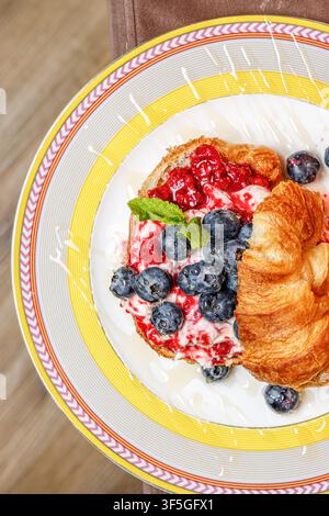 Croissant gourmet con formaggio burrata, bacche fresche e miele Foto Stock