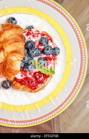 Croissant gourmet con formaggio burrata, bacche fresche e miele Foto Stock