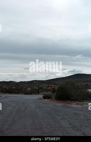 Segnale di stop e marciapiede senza sosta a un incrocio di strada desertica nel Parco nazionale di Joshua Tree Foto Stock
