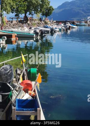 Barca da pesca tradizionale con cassette, canne e contenitori ormeggiata in un piccolo porto tra yacht e barche Foto Stock