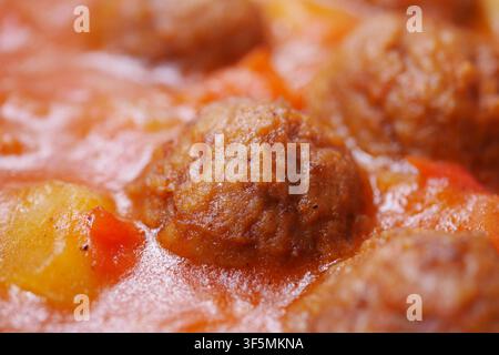 Polpette che cuociono nella salsa di pomodoro in una cucina Foto Stock