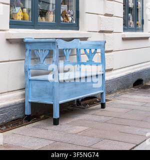 L'ospitalità di strada quotidiana appare su una panchina blu dipinta accanto a una vetrina di un negozio locale a Ribe per il carattere della piccola città, luoghi accoglienti e destinatario Foto Stock