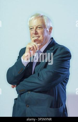 Chris Patten è in piedi con la mano sul mento, immerso nei suoi pensieri durante una conferenza. È vestito con un abito scuro e ha un'espressione seria. Lo sfondo Foto Stock