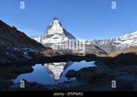 Matterhorn riflesso nel Riffelsee sotto un cielo blu terso nelle Alpi svizzere Foto Stock