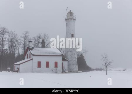 Vista aerea del faro di Sturgeon Point circondato da neve e nebbia ad Harrisville, Michigan, Stati Uniti. Foto Stock
