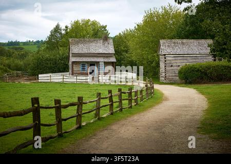 Abitazione e fienile pionieri americani in tronchi con recinto in pali di legno spaccati all'Ulster American Folk Park vicino a Omagh, Contea di Tyrone, Irlanda del Nord Foto Stock