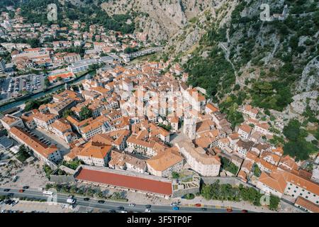 Villaggio mediterraneo illuminato dal sole visto dall'alto. Drone che cattura il porto antico e le strade tortuose Foto Stock
