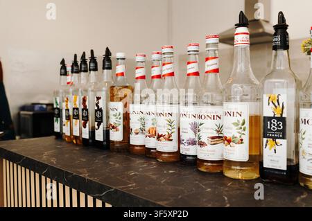 Belgrado, Serbia - 29 luglio 2026. Bottiglie di sciroppi aromatizzati Monin e 1883 disposte su un bancone del caffè, che mostrano una selezione di ingredienti per bevande Foto Stock