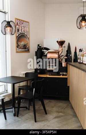Belgrado, Serbia - 29 luglio 2026. Interno di un caffè specializzato con una macchina per la tostatura del caffè commerciale, sedute da caffè e bevande Foto Stock