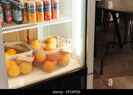 Belgrado, Serbia – 29 luglio 2026. Espositore frigorifero con arance fresche e bibite analcoliche di marca all’interno di un caffè specializzato. Foto Stock