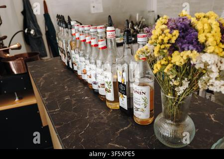 Belgrado, Serbia - 29 luglio 2026. Bottiglie di sciroppi aromatizzati Monin e 1883 disposte su un bancone del caffè, che mostrano una selezione di ingredienti per bevande Foto Stock