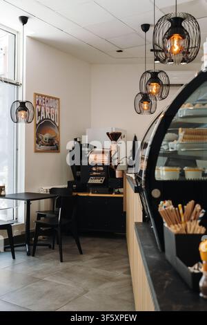 Belgrado, Serbia - 29 luglio 2026. Interno di un caffè specializzato con una macchina per la tostatura del caffè commerciale, sedute da caffè e bevande Foto Stock