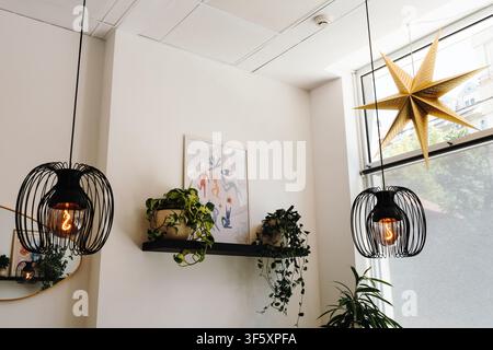 Belgrado, Serbia - 29 luglio 2026. Interno di un caffè specializzato con illuminazione decorativa, piante da interno e design moderno. Foto Stock