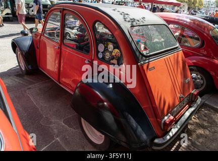 Tavernes Blanques, Spagna – 14 giugno 2026. Una Citroën vintage arancione e nera è parcheggiata, mostrando il profilo laterale e la vista posteriore. Altre auto classiche s Foto Stock