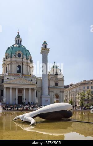 Scultura gonfiabile di balena in una piscina riflettente presso la chiesa di San Carlo (Karlskirche) in Karlsplatz, Vienna, Austria. Foto Stock
