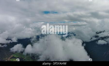 Vista aerea delle montagne innevate tra le nuvole Foto Stock