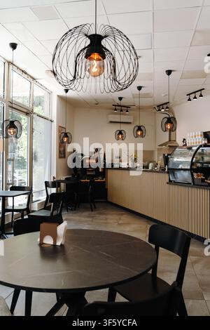 Belgrado, Serbia - 29 luglio 2026. Interno di un caffè specializzato con una macchina per la tostatura del caffè commerciale, sedute da caffè e bevande Foto Stock