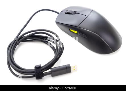 Un mouse da computer moderna nera cablata e il suo cavo USB ordinatamente arrotolato sono mostrati isolati su uno sfondo bianco pulito Foto Stock