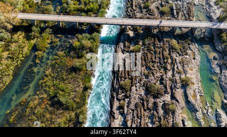 Veduta aerea del ponte del canale di Bunski che si estende sul fiume Neretva, mostrando rapidi, rive rocciose e vegetazione rigogliosa Foto Stock