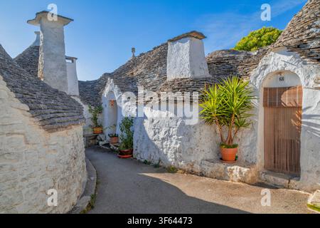 Case trulli tradizionali lungo una strada stretta nel centro storico di Alberobello. Alberobello, Provincia di Bari, Puglia, Italia Foto Stock