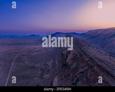 Veduta aerea grandangolare con drone lungo una cresta rocciosa sopra le pianure desertiche di Aggeneys, Capo Settentrionale Foto Stock