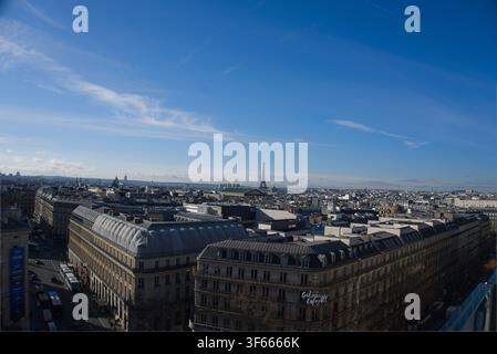 Parigi, Francia – Vista panoramica dal tetto sulle coperture di Parigi verso la lontana Torre Eiffel sotto un cielo blu terso. Foto Stock
