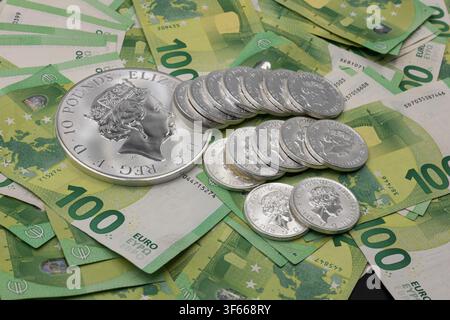 Monete d'argento su banconote in euro che rappresentano investimento, ricchezza e sicurezza finanziaria Foto Stock
